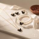 The Butterfly Pearl set arranged on a marble slab with rose petals