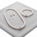 The Pearl Row set on grey linen: pearl necklace and bracelet with the crystal ball accent, and the pearl studs