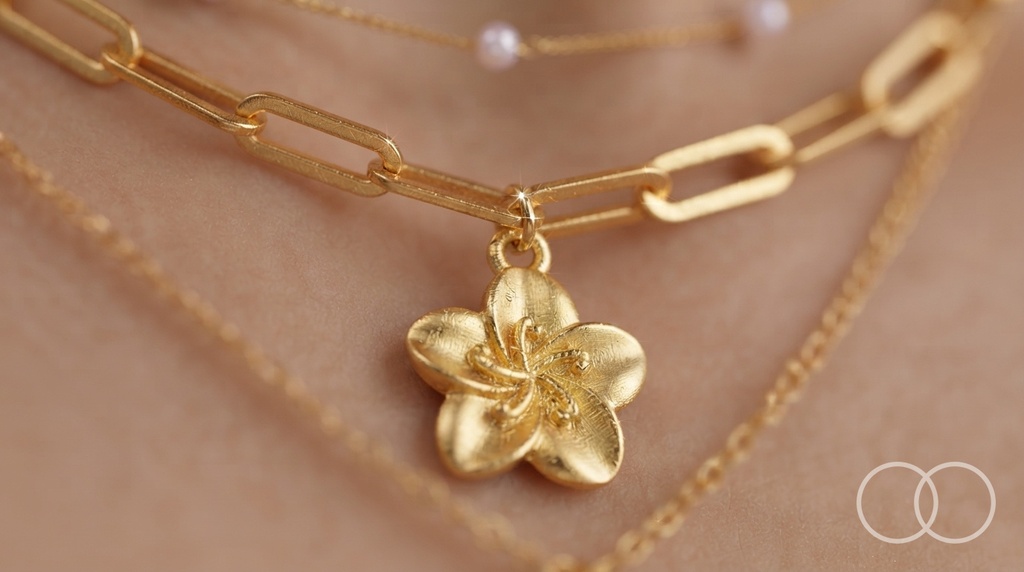 Close up of the gold flower pendant and the paperclip chain links