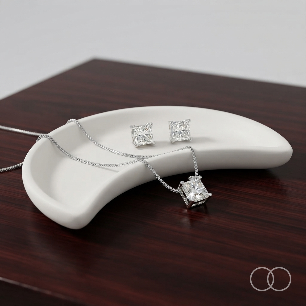The pendant and studs in a ceramic dish on dark wood