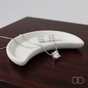 The pendant and studs in a ceramic dish on dark wood