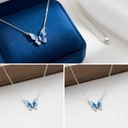 Butterfly pendant on a velvet gift box and on a wooden ledge