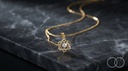 The Six-Point pendant and chain on a black marble slab